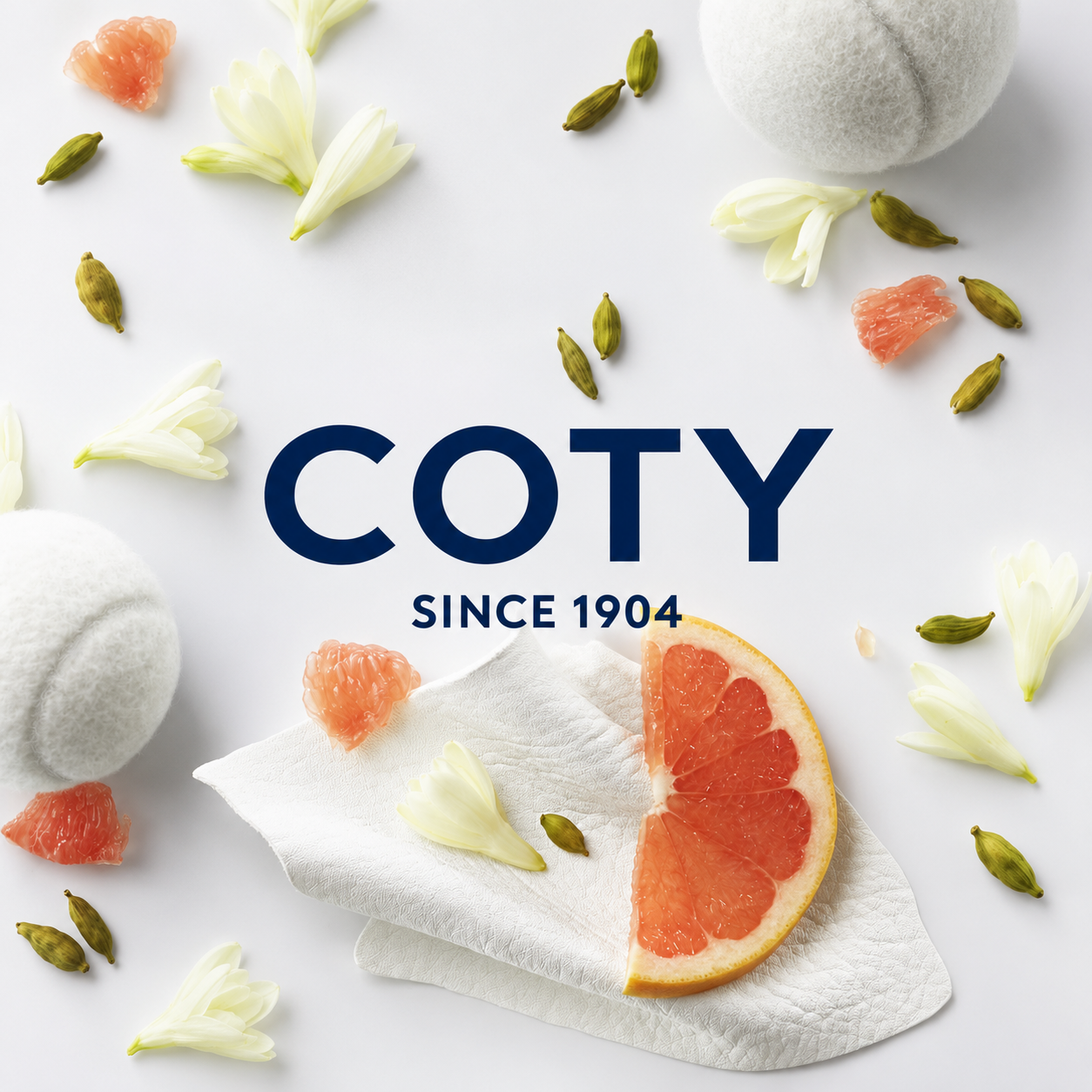 Coty logo over white fragrance still life